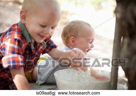 Toddler twins splashing in bowl of water View Large Photo Image Stock Image - Toddler twins splashing in bowl of water. Fotosearch