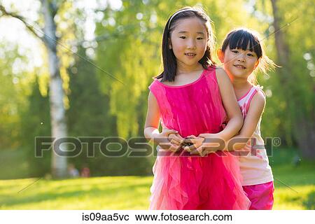 Stock Image - Two girls hugging, portrait. Fotosearch
