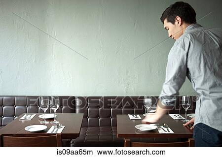 Waiter setting table in restaurant View Large Photo Image Picture - Waiter setting table in restaurant. Fotosearch