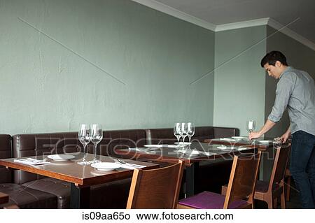 Picture - Waiter setting table in restaurant. Fotosearch