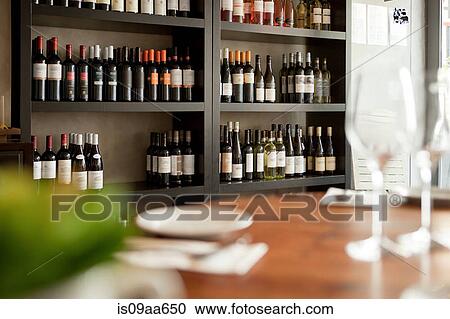 Stock Image - Wine bottles on shelves in restaurant. Fotosearch