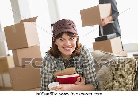 Woman sitting with books whilst moving home View Large Photo Image Stock Photo - Woman sitting with books whilst moving home. Fotosearch