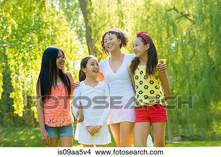 Picture - Woman with three girls in park. Fotosearch