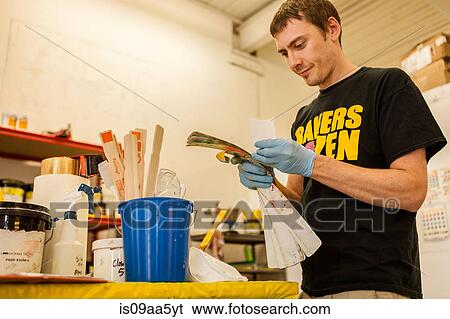 Stock Photograph - Worker looking at swatches in screen print workshop. Fotosearch