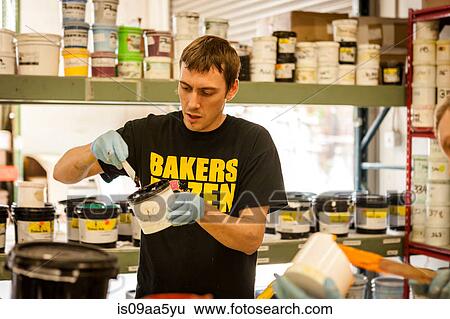 Stock Photograph - Worker mixing ink in screen print workshop. Fotosearch