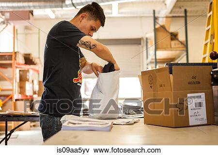 Worker packing garment in screen print workshop View Large Photo Image Stock Photo - Worker packing garment in screen print workshop. Fotosearch
