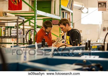 Picture - Workers checking color swatches in screen print workshop. Fotosearch