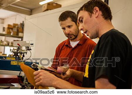 Workers looking at swatches in screen printing workshop View Large Photo Image Stock Photograph - Workers looking at swatches in screen printing workshop. Fotosearch