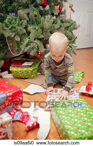 Young boy looking at Christmas presents View Large Photo Image Stock Image - Young boy looking at Christmas presents. Fotosearch