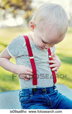 Young boy looking at trousers braces View Large Photo Image Picture - Young boy looking at trousers braces. Fotosearch