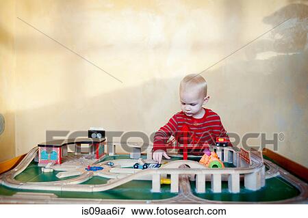 Young boy playing with toy train set View Large Photo Image Stock Photo - Young boy playing with toy train set. Fotosearch