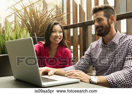Young business colleagues looking at laptop in meeting View Large Photo Image Stock Photography - Young business colleagues looking at laptop in meeting. Fotosearch