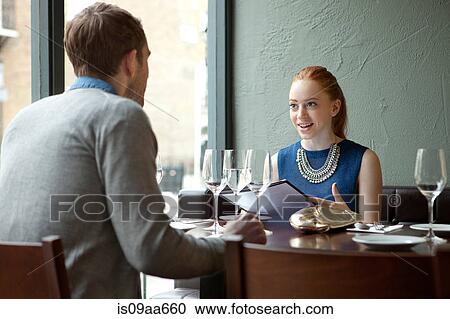 Stock Image - Young couple in restaurant with menu. Fotosearch
