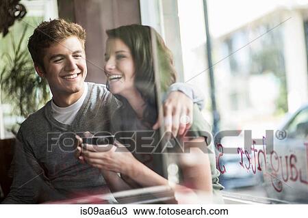 Stock Image - Young couple sharing coffee in cafe. Fotosearch