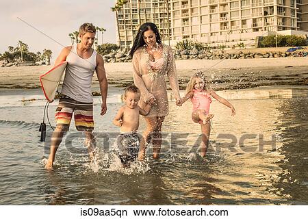 Picture - Young family paddling through water. Fotosearch