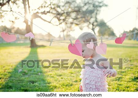 Young girl next to heart shapes on washing line View Large Photo Image Stock Photograph - Young girl next to heart shapes on washing line. Fotosearch