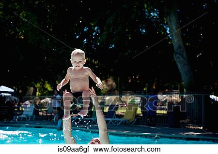 Stock Image - Young male toddler in swimming pool with father. Fotosearch