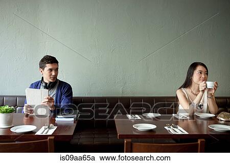 Stock Image - Young man looking at young woman in restaurant. Fotosearch