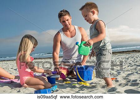 Young man playing with son and daughter on beach View Large Photo Image Stock Image - Young man playing with son and daughter on beach. Fotosearch