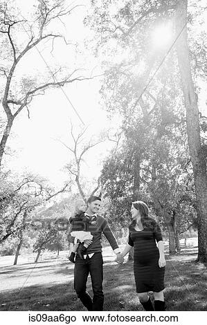 Young parents strolling in park with female toddler View Large Photo Image Picture - Young parents strolling in park with female toddler. Fotosearch