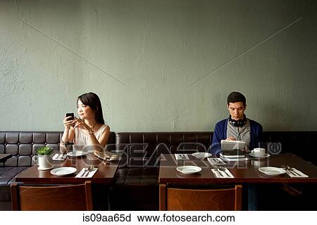 Stock Image - Young woman and young man in restaurant. Fotosearch