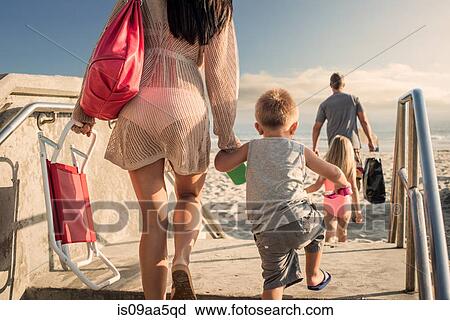 Young woman arriving at beach with son View Large Photo Image Stock Image - Young woman arriving at beach with son. Fotosearch
