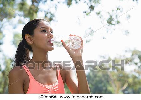 Young woman drinking from water bottle View Large Photo Image Stock Image - Young woman drinking from water bottle. Fotosearch