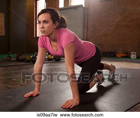 Stock Photo - Young woman exercising in gym. Fotosearch