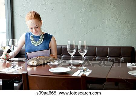 Young woman in restaurant, reading menu View Large Photo Image Stock Photography - Young woman in restaurant, reading menu. Fotosearch
