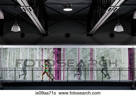 Stock Photograph - Young woman jogging on gym balcony. Fotosearch