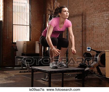 Young woman jumping on table in gym View Large Photo Image Stock Photograph - Young woman jumping on table in gym. Fotosearch