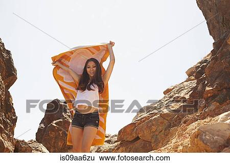 Stock Photograph - Young woman lifting towel, Palos Verdes, California, USA. Fotosearch