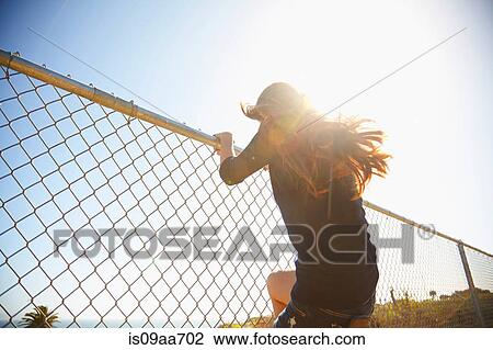 Young woman messing about on wire fence View Large Photo Image Stock Image - Young woman messing about on wire fence. Fotosearch