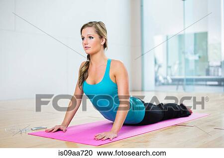Young woman on mat in yoga position View Large Photo Image Stock Image - Young woman on mat in yoga position. Fotosearch