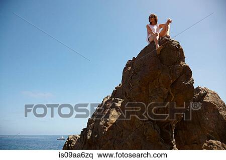Stock Photography - Young woman on top of rocks, Palos Verdes, California, USA. Fotosearch