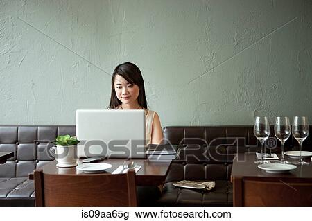 Young woman using laptop in restaurant View Large Photo Image Stock Image - Young woman using laptop in restaurant. Fotosearch