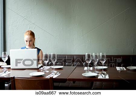 Young woman using laptop in restaurant View Large Photo Image Stock Photo - Young woman using laptop in restaurant. Fotosearch