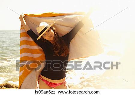 Stock Photo - Young woman with beach towel, Palos Verdes, California, USA. Fotosearch