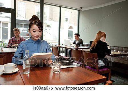 Stock Photography - Young woman with digital tablet in cafe. Fotosearch