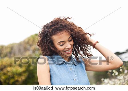 Young woman with hand in hair, smiling View Large Photo Image Stock Image - Young woman with hand in hair, smiling. Fotosearch