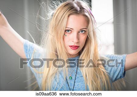 Young woman with windswept hair, portrait View Large Photo Image Stock Photograph - Young woman with windswept hair, portrait. Fotosearch