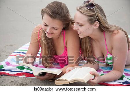 Young women reading books on beach View Large Photo Image Stock Photography - Young women reading books on beach. Fotosearch