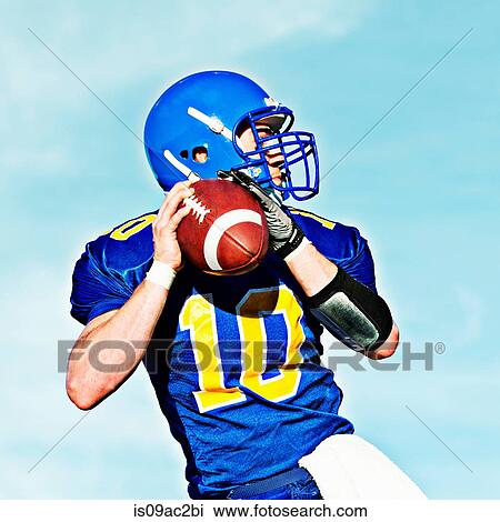 Stock Image - American footballer holding ball. Fotosearch
