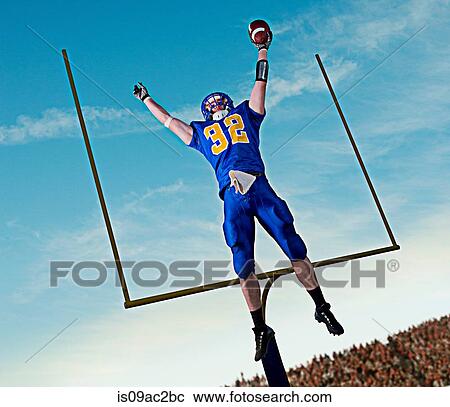 American footballer jumping to catch ball in front of goal View Large Photo Image Stock Image - American footballer jumping to catch ball in front of goal. Fotosearch