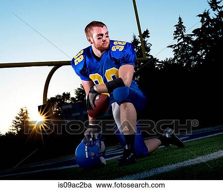 American footballer kneeling on pitch View Large Photo Image Stock Image - American footballer kneeling on pitch. Fotosearch