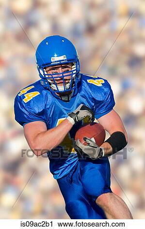Stock Image - American footballer running with ball. Fotosearch