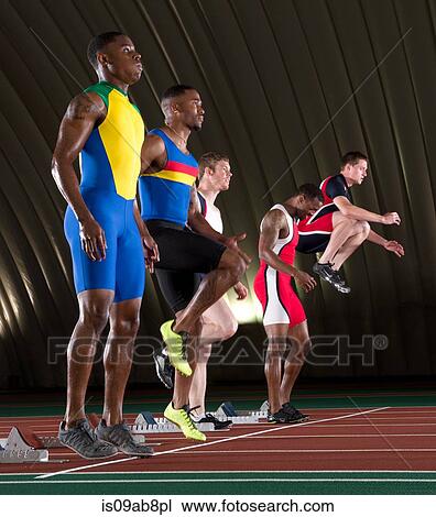 Stock Image - Athletes standing at start line of race. Fotosearch