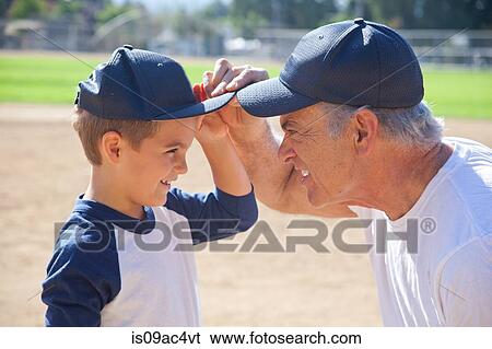 Boy and grandfather in baseball caps, face to face View Large Photo Image Stock Photograph - Boy and grandfather in baseball caps, face to face. Fotosearch