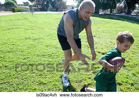 Boy and grandfather playing american football View Large Photo Image Stock Image - Boy and grandfather playing american football. Fotosearch
