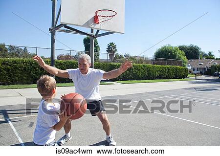 Picture - Boy and grandfather playing basketball. Fotosearch